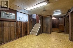Lower level featuring wood-finish paneling, a tiled staircase, and patterned flooring - 