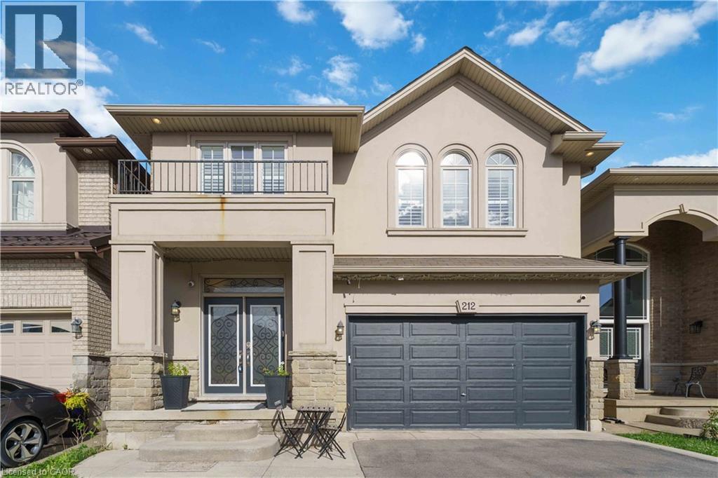 Stucco exterior featuring stone accents, a covered front entry, and a second-story balcony with metal railings - 212 Chartwell Circle, Hamilton, ON - Outdoor With Facade