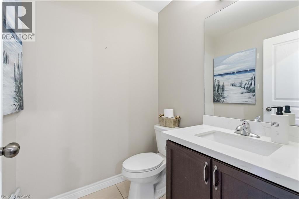 Vanity with a white countertop and integrated sink, chrome faucet, and dark wood-finish cabinetry - 212 Chartwell Circle, Hamilton, ON - Indoor Photo Showing Bathroom