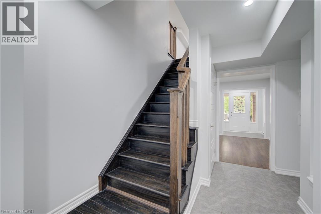 Wood-finish staircase with natural wood handrail and balusters - 911 Apple Hill Lane, Kitchener, ON - Indoor Photo Showing Other Room