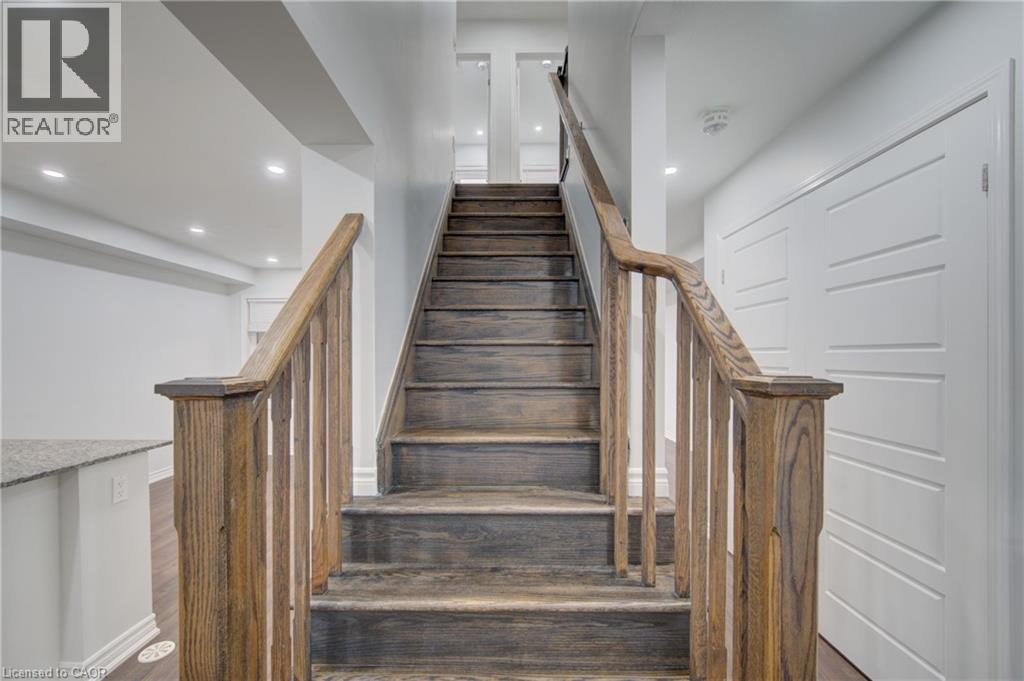 Staircase featuring wood-finish treads and balusters, painted risers, and white baseboards - 911 Apple Hill Lane, Kitchener, ON - Indoor Photo Showing Other Room