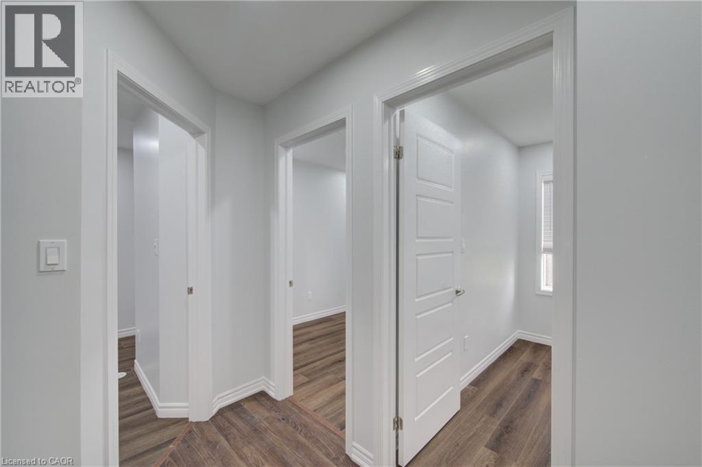 Hallway featuring wood-finish flooring, white trim, and light gray walls - 911 Apple Hill Lane, Kitchener, ON - Indoor Photo Showing Other Room
