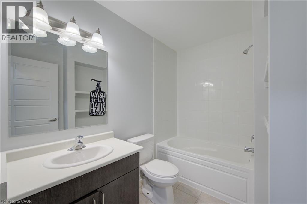 Contemporary bathroom featuring a dark wood-finish vanity with a white countertop and undermount sink - 911 Apple Hill Lane, Kitchener, ON - Indoor Photo Showing Bathroom
