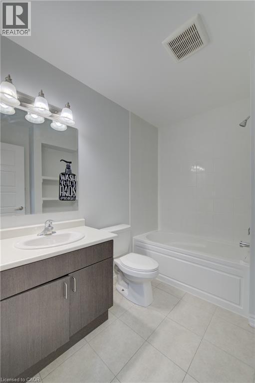 Bathroom featuring a white bathtub, toilet, and a vanity with a white countertop and integrated sink - 911 Apple Hill Lane, Kitchener, ON - Indoor Photo Showing Bathroom