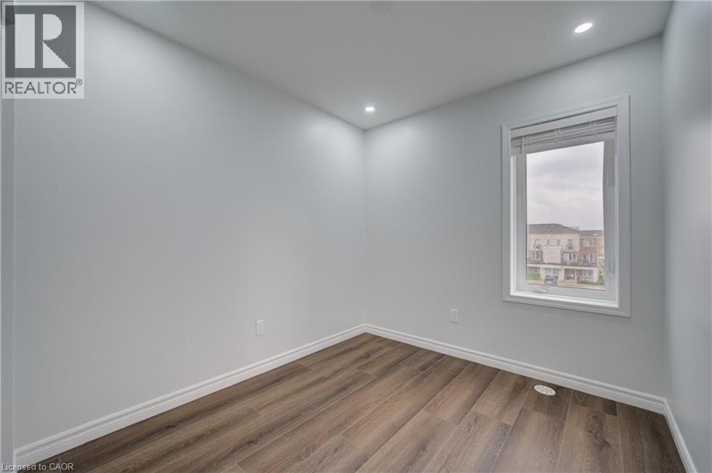 Room featuring wood-finish flooring, white baseboards, and neutral wall paint - 911 Apple Hill Lane, Kitchener, ON - Indoor Photo Showing Other Room