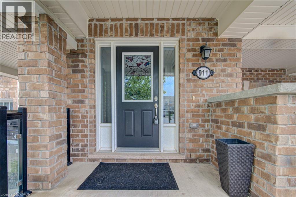 Brick exterior featuring a paneled entry door with decorative glass inserts and clear side lites - 911 Apple Hill Lane, Kitchener, ON - With Exterior