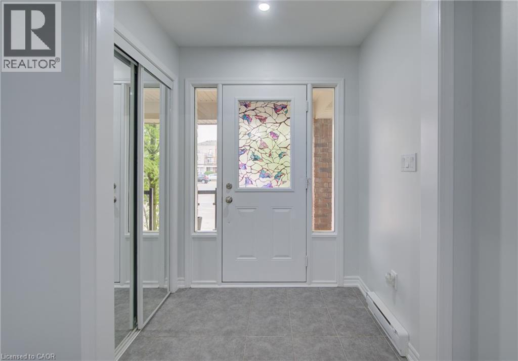 Front entry featuring a white door with decorative glass, two sidelight windows, and a transom window - 911 Apple Hill Lane, Kitchener, ON - Indoor Photo Showing Other Room