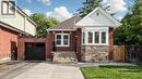 Brick exterior featuring a stone accent bay window with white trim, a concrete driveway, and an integrated single-car garage with a modern black door - 59 Longwood Road N, Hamilton, ON  - Outdoor 