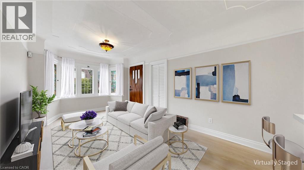 Living area featuring light wood-finish flooring and a distinctive bay window with multiple panes - 59 Longwood Road N, Hamilton, ON - Indoor