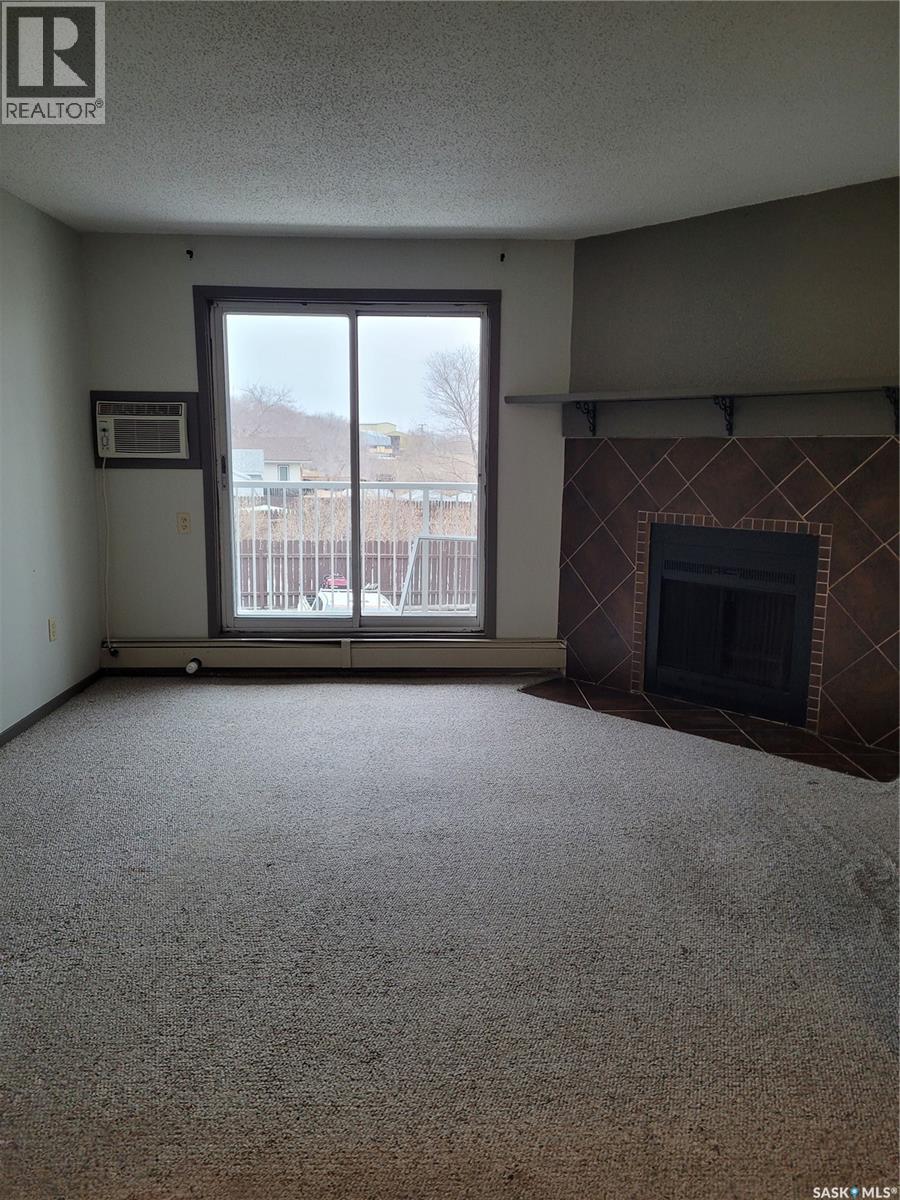205 306 Perkins Street, Estevan, SK - Indoor Photo Showing Living Room With Fireplace