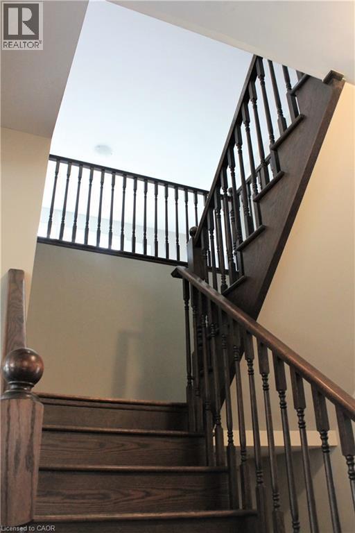 Dark wood staircase featuring a turned newel post and balusters, with light-colored walls and a white ceiling - 31 Pointer Street Unit# Main Floor, Cambridge, ON - Indoor Photo Showing Other Room