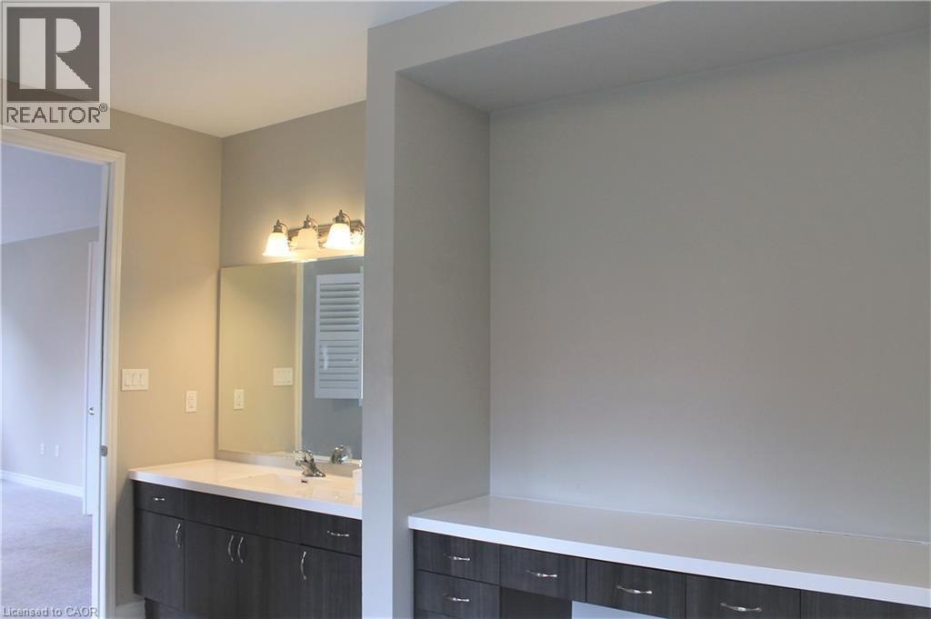 Vanity area featuring a built-in countertop, undermount sink, and a multi-bulb light fixture - 31 Pointer Street Unit# Main Floor, Cambridge, ON - Indoor Photo Showing Bathroom