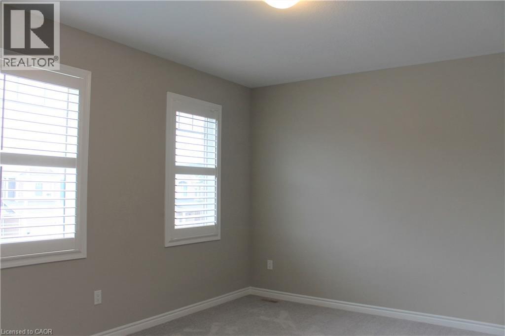 Neutral-toned room featuring two windows with white plantation shutters, light gray wall paint, white baseboards, and wall-to-wall carpeting - 31 Pointer Street Unit# Main Floor, Cambridge, ON - Indoor Photo Showing Other Room