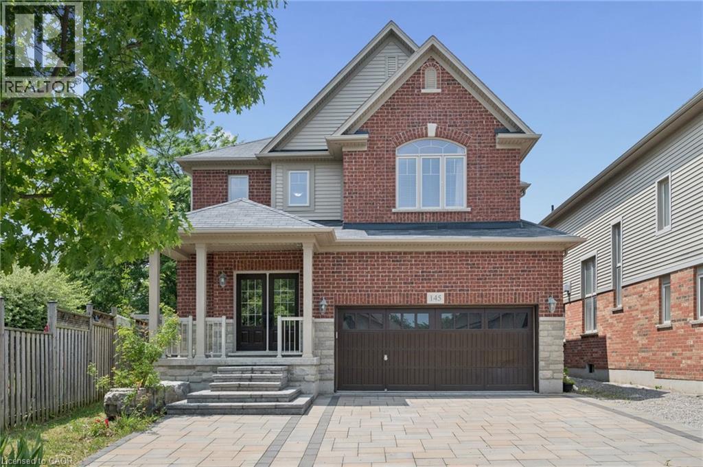 Brick and siding exterior with a covered porch, stone steps, and a paver driveway - 145 Redtail Street, Kitchener, ON - Outdoor