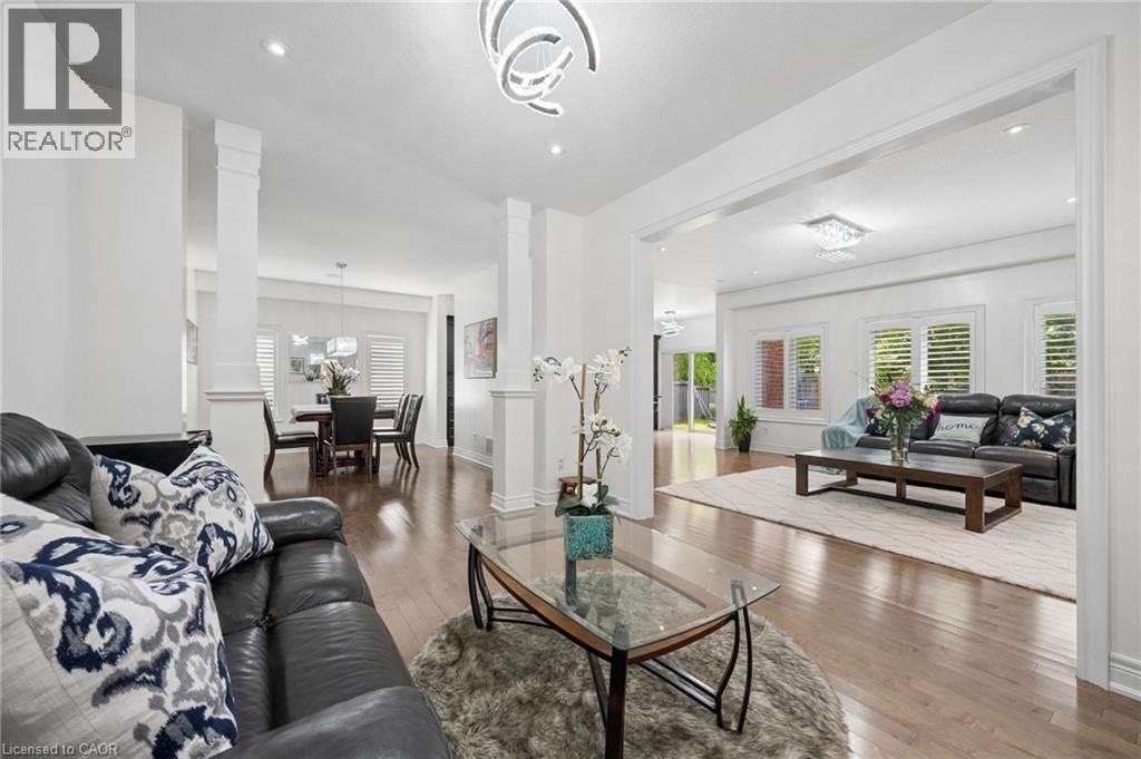 Expansive living room featuring wood-finish flooring, recessed lighting, and decorative columns - 145 Redtail Street, Kitchener, ON - Indoor Photo Showing Living Room
