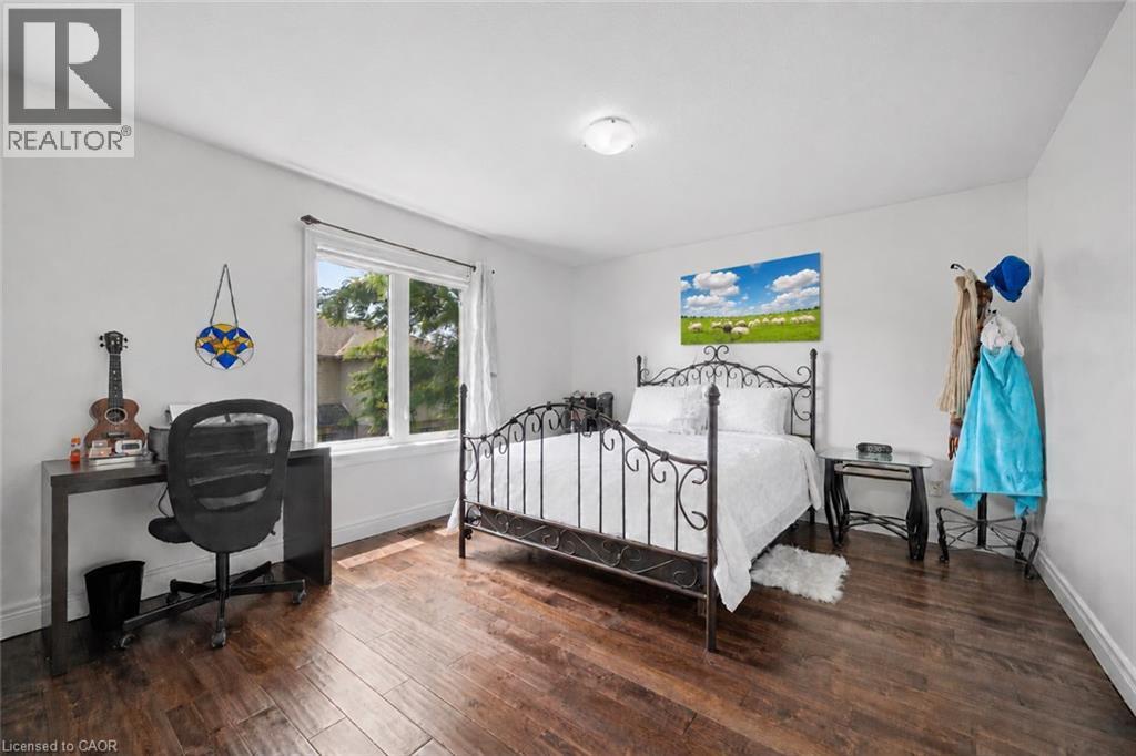 Bright room featuring wood-finish flooring and a large window - 145 Redtail Street, Kitchener, ON - Indoor Photo Showing Bedroom