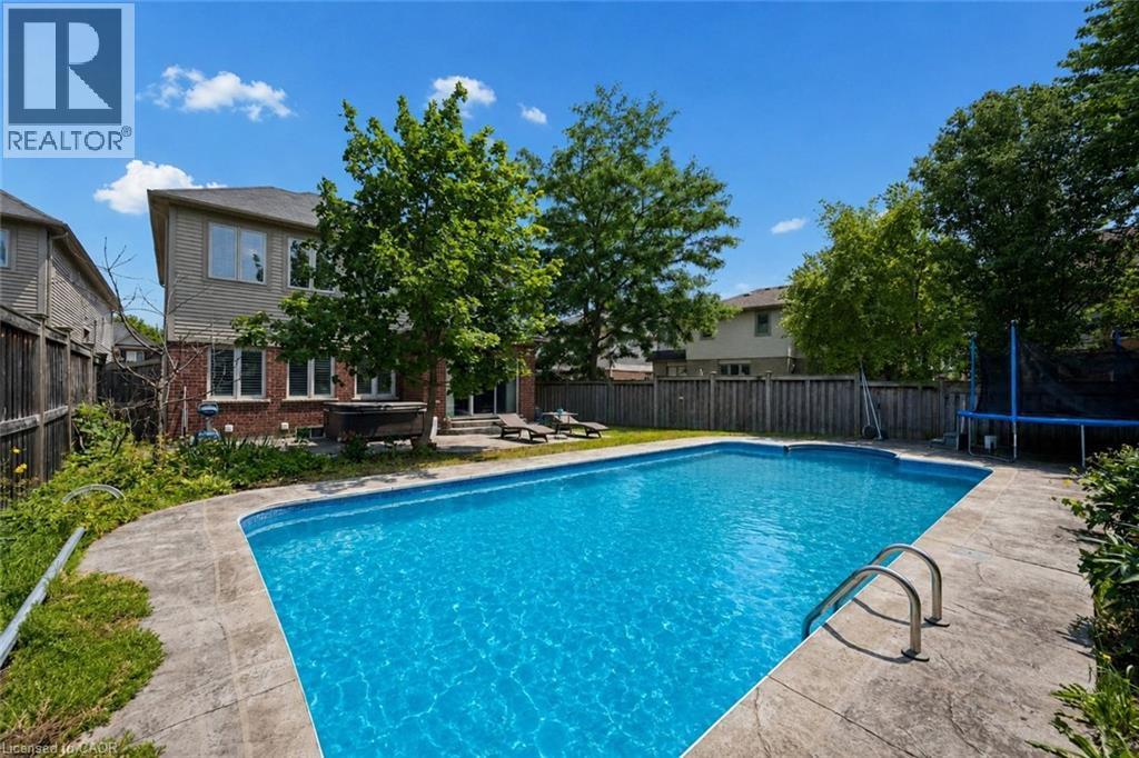 Expansive backyard featuring an in-ground swimming pool with stone coping and stainless steel ladder - 145 Redtail Street, Kitchener, ON - Outdoor With In Ground Pool With Backyard