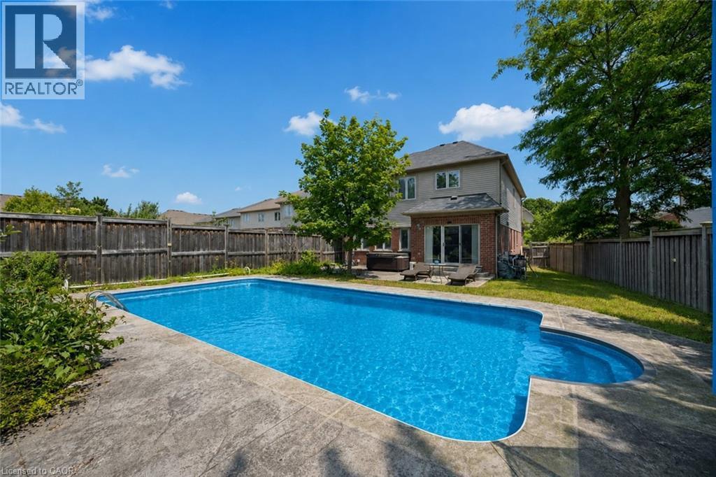 Spacious backyard featuring an in-ground swimming pool with an integrated spa - 145 Redtail Street, Kitchener, ON - Outdoor With In Ground Pool With Deck Patio Veranda With Backyard