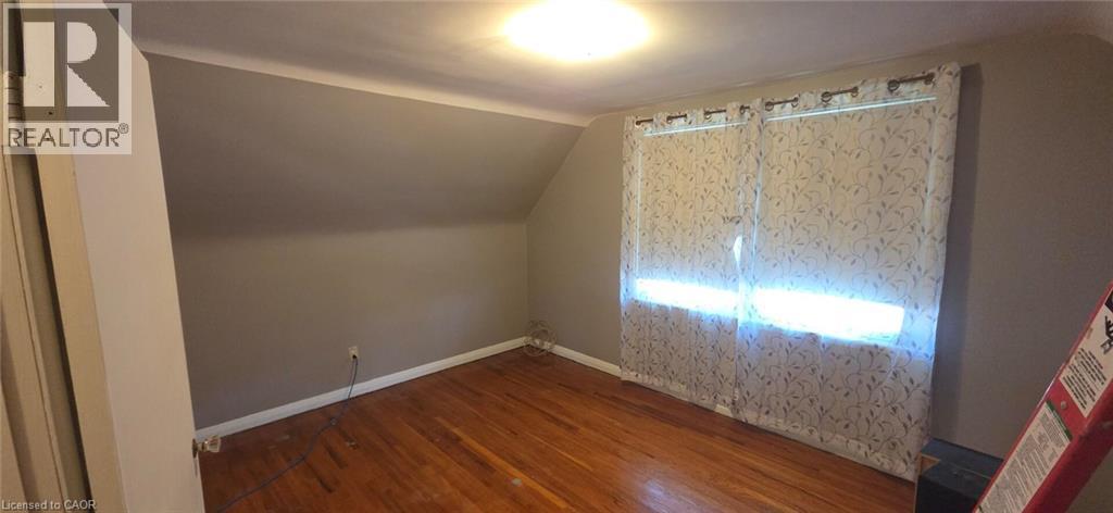 Room with wood-finish flooring, neutral-toned walls, and a sloped ceiling - 274 East 38Th Street, Hamilton, ON - Indoor Photo Showing Other Room