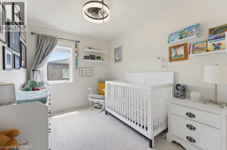 Light-filled room featuring neutral wall paint, white trim, and light-colored carpeting - 16 Raspberry Lane, Hamilton, ON - Indoor Photo Showing Bedroom