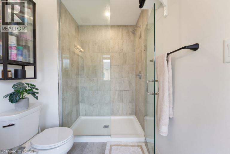 Glass-enclosed shower featuring light-toned tile surround and a rectangular base - 16 Raspberry Lane, Hamilton, ON - Indoor Photo Showing Bathroom