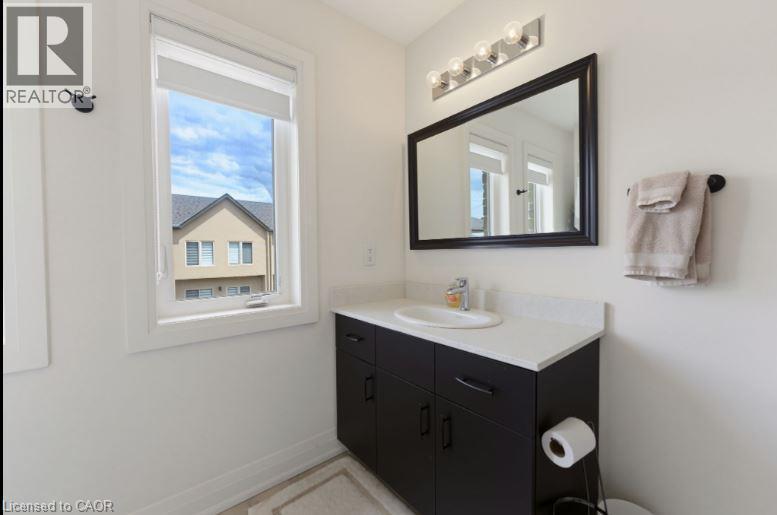 Contemporary vanity with white countertop, integrated sink, and dark cabinetry - 16 Raspberry Lane, Hamilton, ON - Indoor Photo Showing Bathroom