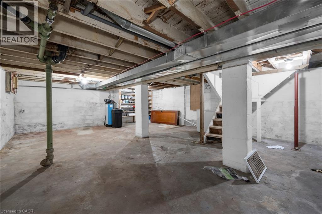 Unfinished basement featuring exposed ceiling joists, concrete flooring, and visible plumbing and ductwork - 29 Harrison Avenue, Hamilton, ON - Indoor Photo Showing Basement