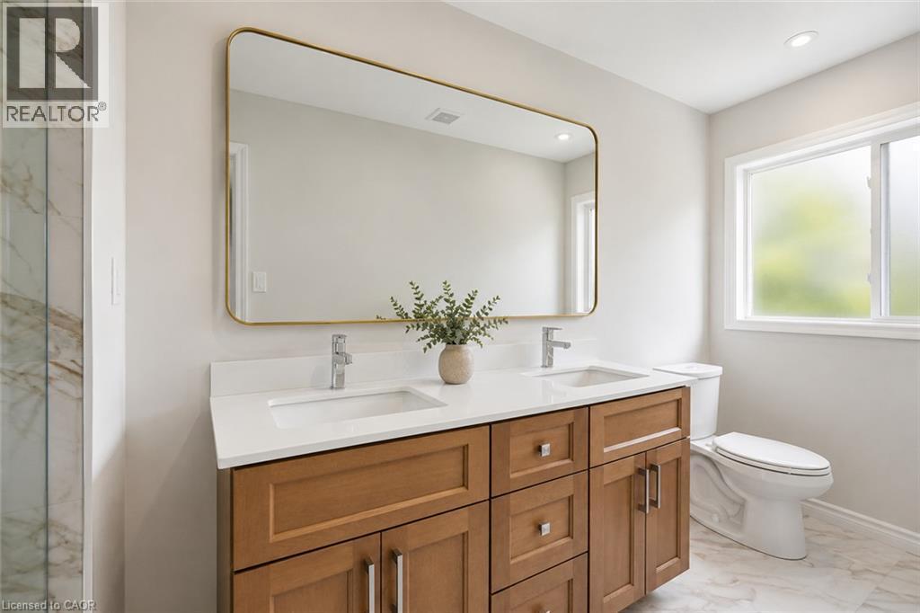 Dual vanity with wood-finish cabinetry and white countertop - 5628 Stella Lane, Burlington, ON - Indoor Photo Showing Bathroom