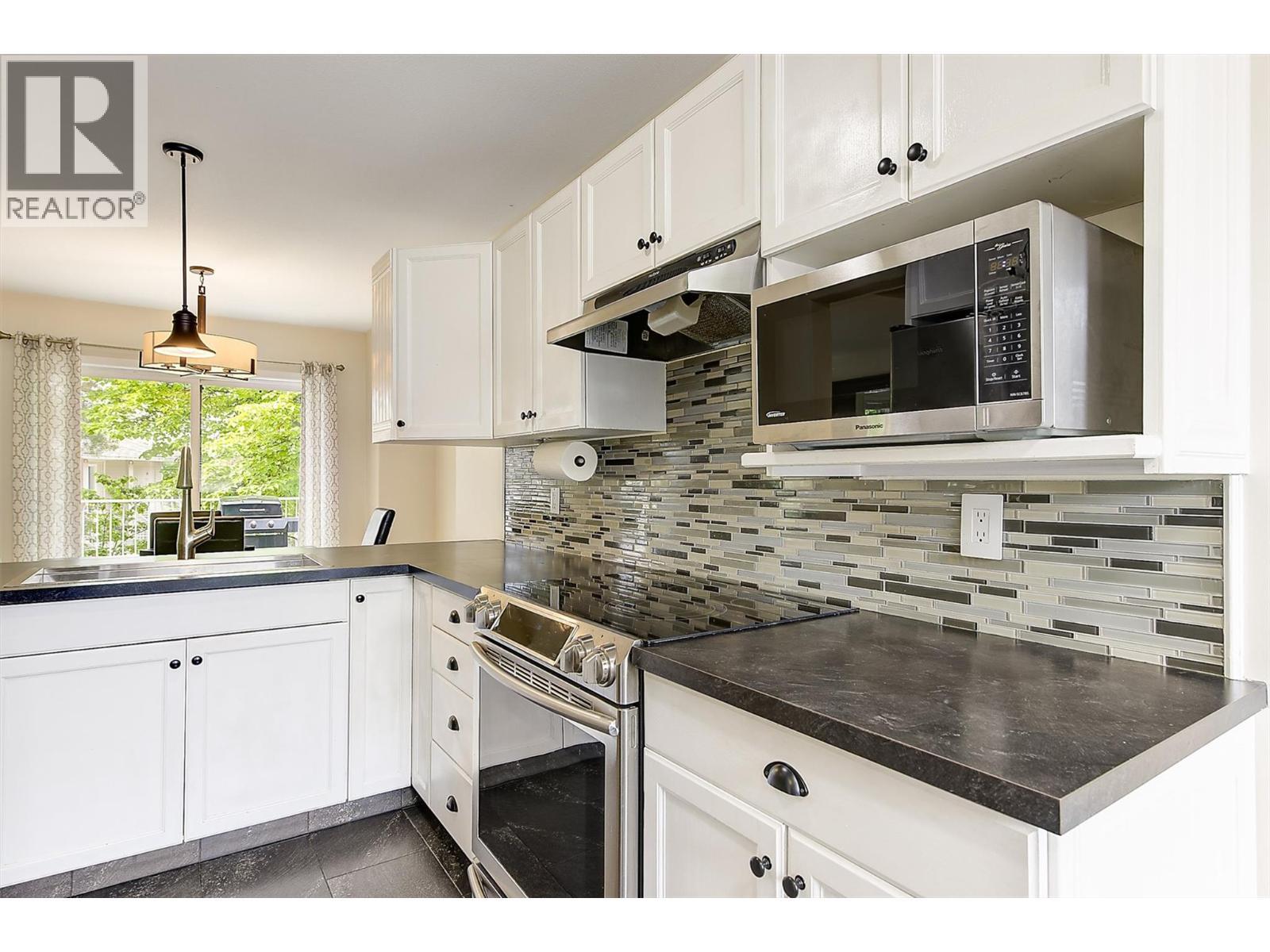 Functional kitchen with stainless steel appliances - 133 Wyndham Crescent Unit# 110, Kelowna, BC - Indoor Photo Showing Kitchen With Upgraded Kitchen