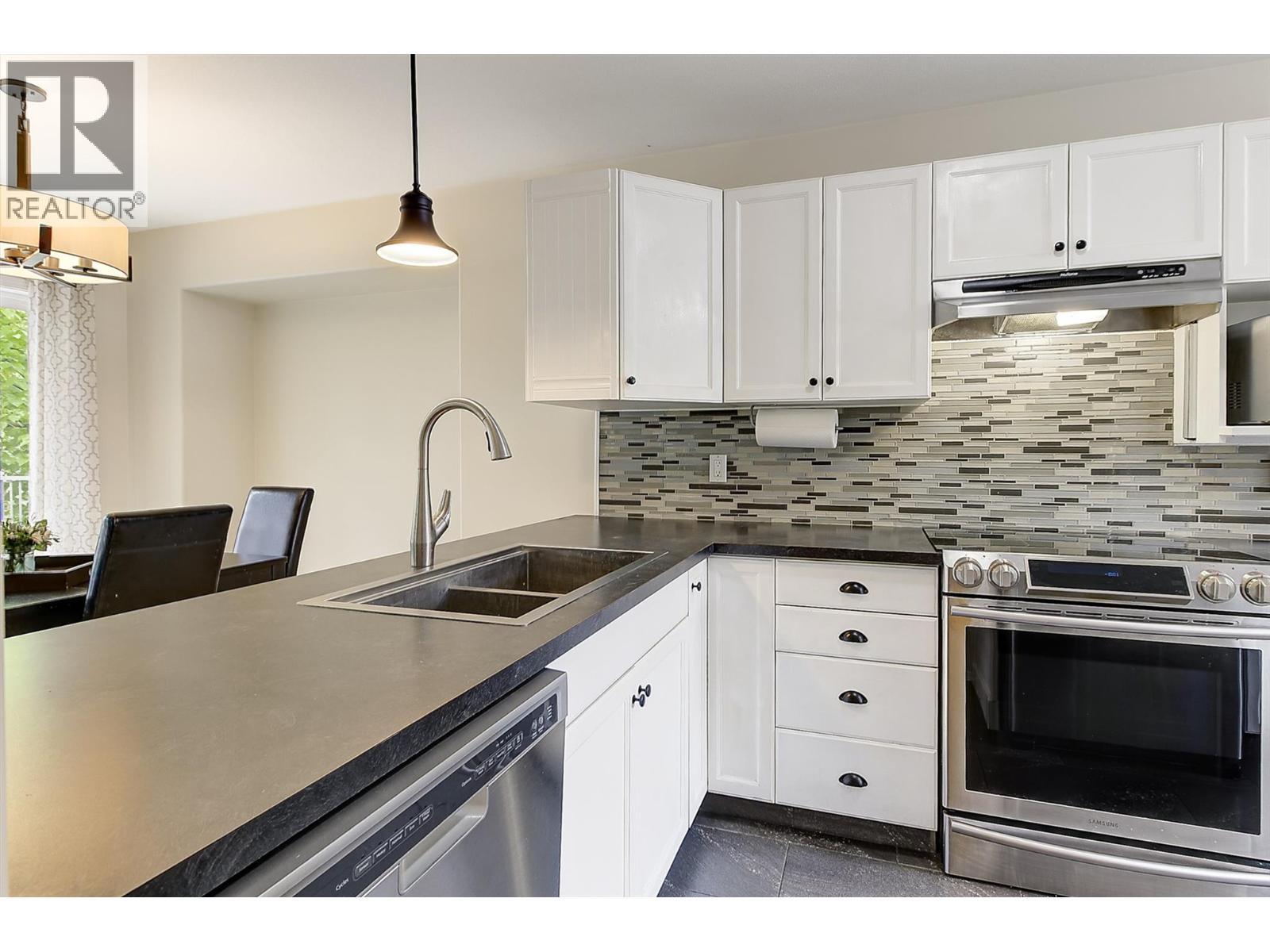 Kitchen to Dining - 133 Wyndham Crescent Unit# 110, Kelowna, BC - Indoor Photo Showing Kitchen With Double Sink