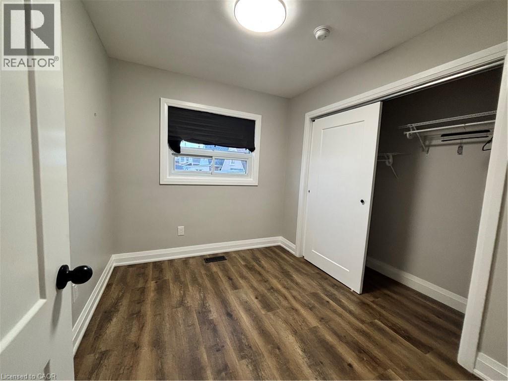 Interior room featuring wood-finish flooring, light grey walls, and white trim - 773 Lawrence Road, Hamilton, ON - Indoor Photo Showing Other Room