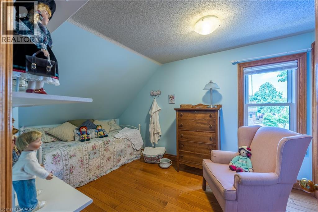 Room featuring sloped ceilings, hardwood flooring, and a single window with wood trim - 5 Hawthorne Avenue, Simcoe, ON - Indoor