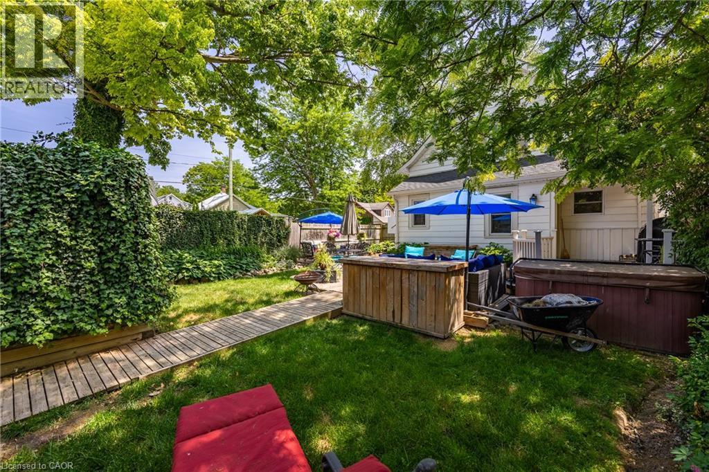 Expansive backyard featuring a manicured lawn and mature trees - 5 Hawthorne Avenue, Simcoe, ON - Outdoor With Backyard