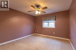 Carpeted room with a ceiling fan light fixture -