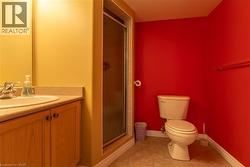 Dedicated laundry area featuring white upper cabinetry, a utility sink with dual faucets, and tiled flooring -
