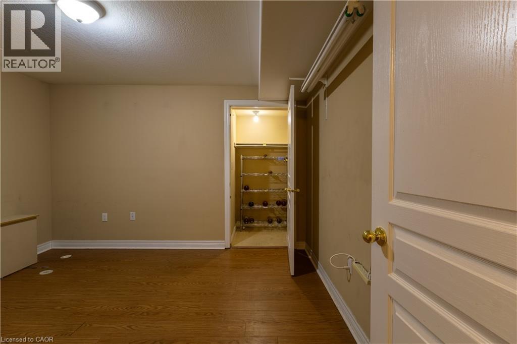 Interior room featuring wood-finish flooring, light beige walls, and white baseboards - 4066 Medland Drive, Burlington, ON - Indoor Photo Showing Other Room