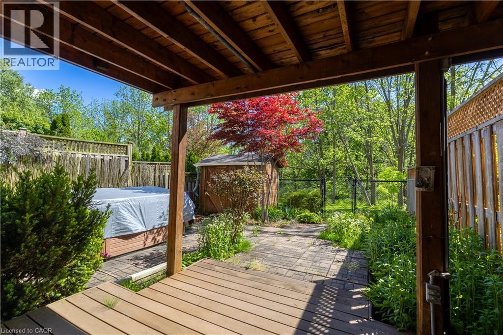 Covered outdoor patio with wood-finish decking and exposed beam ceiling - 4066 Medland Drive, Burlington, ON - Outdoor With Deck Patio Veranda With Exterior