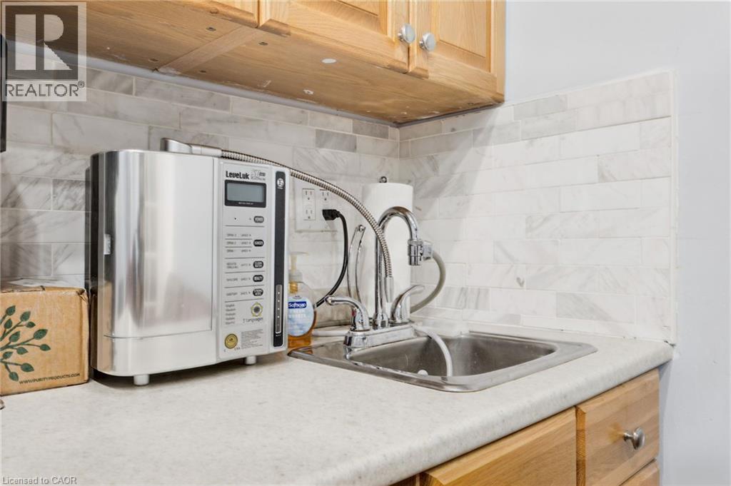 Compact stainless steel sink with a chrome faucet, set into a laminate countertop - 189 Hughson Street, Hamilton, ON