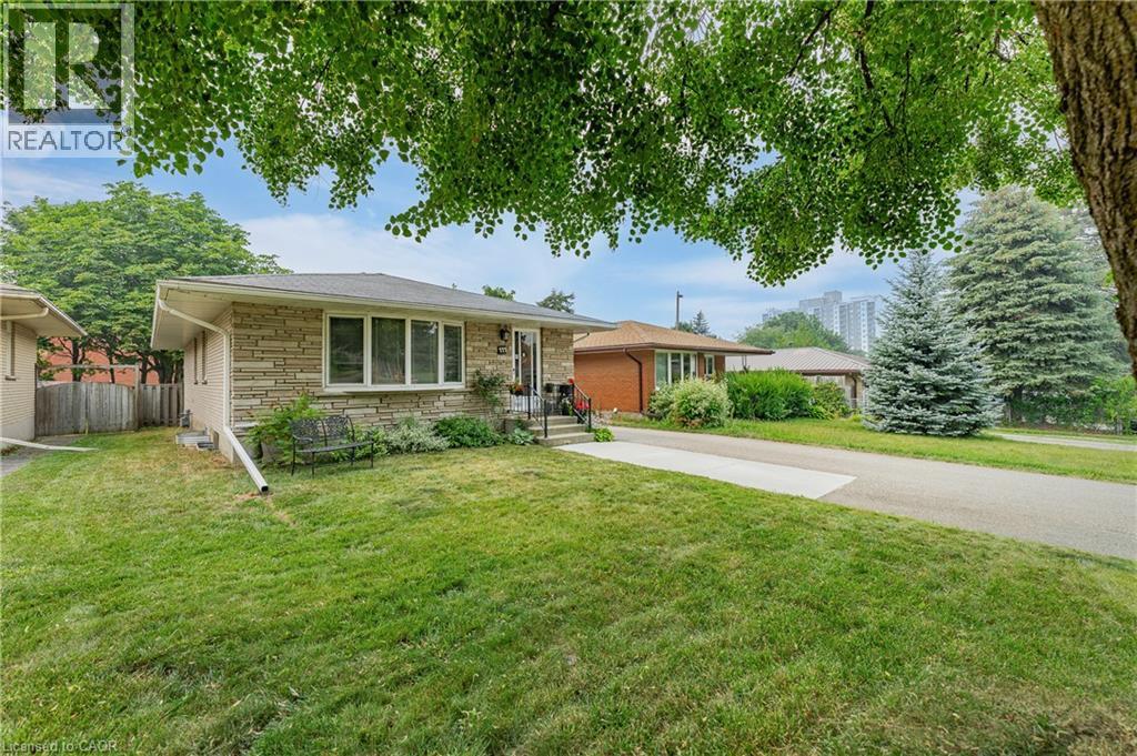 Stone facade residence featuring a front yard with mature trees - 111 Kimberly Crescent, Kitchener, ON - Outdoor