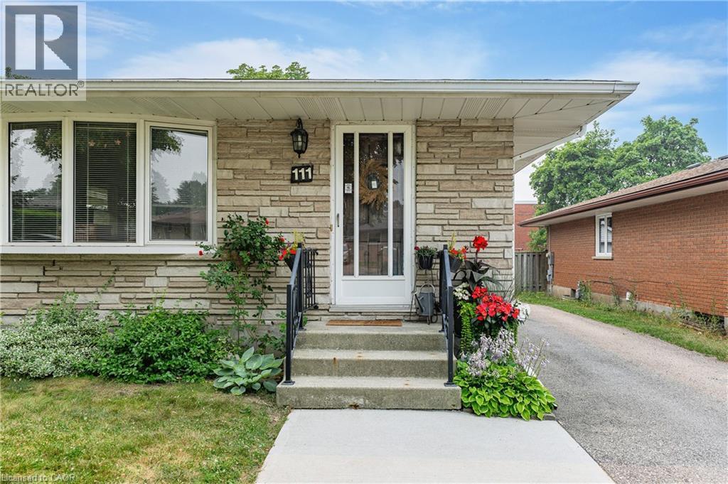 Front entrance featuring stone veneer siding, concrete steps with metal railings, a full-lite entry door, and a bay window - 111 Kimberly Crescent, Kitchener, ON - Outdoor