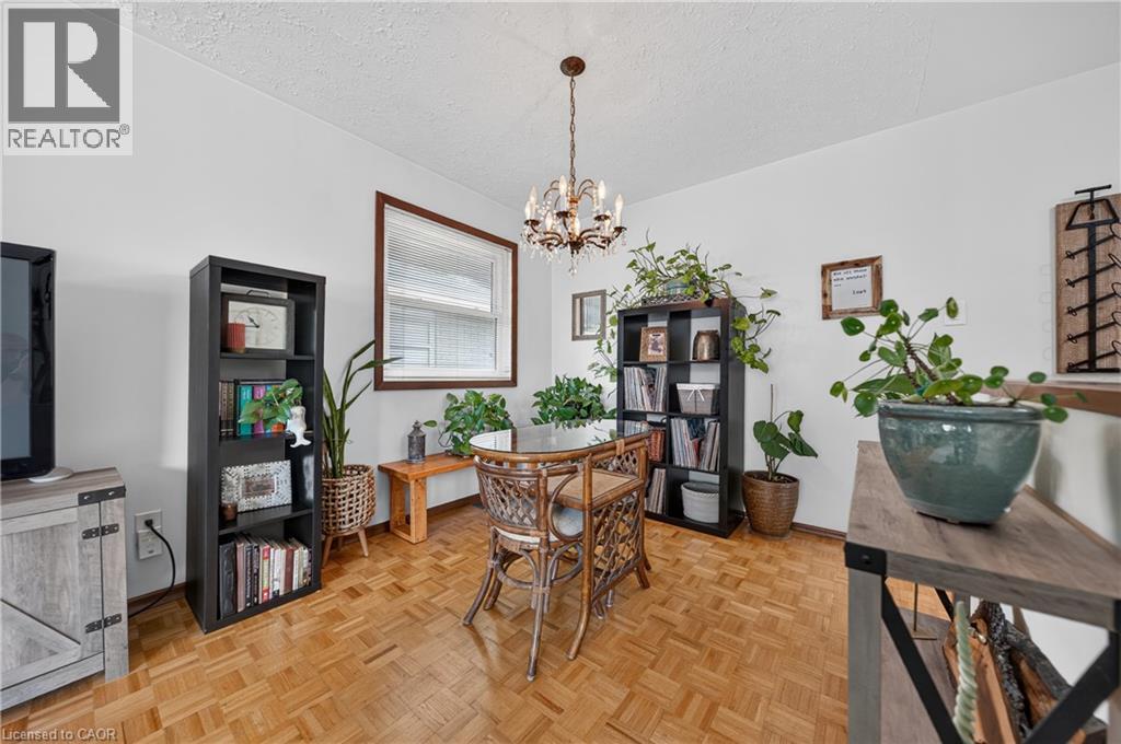 Dining area featuring wood-finish parquet flooring, a chandelier light fixture, and a window with a wood frame - 111 Kimberly Crescent, Kitchener, ON - Indoor Photo Showing Dining Room