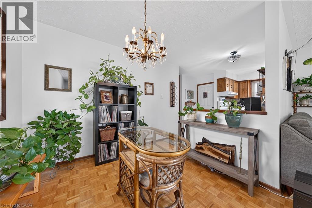 Dining area with parquet wood-finish flooring and a crystal chandelier - 111 Kimberly Crescent, Kitchener, ON - Indoor Photo Showing Dining Room