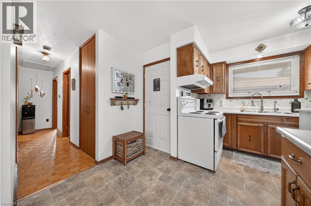 Kitchen featuring wood cabinetry, white appliances, a tile backsplash, and a window above the sink - 111 Kimberly Crescent, Kitchener, ON - Indoor Photo Showing Kitchen