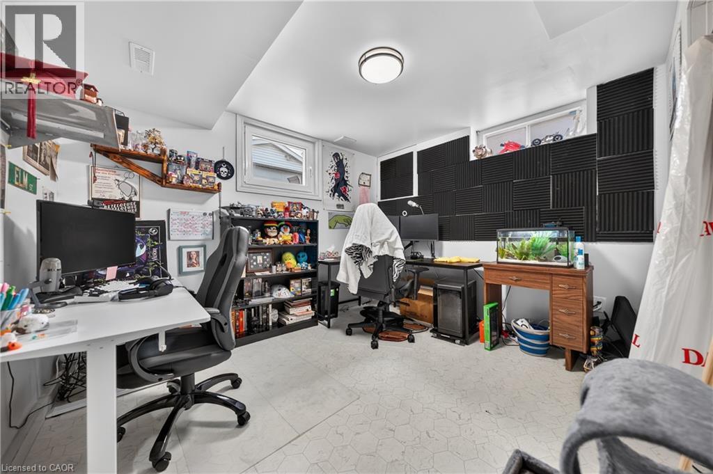 Finished room featuring a ceiling-mounted light fixture, multiple windows, built-in shelving, and sound-dampening wall panels - 111 Kimberly Crescent, Kitchener, ON - Indoor Photo Showing Office