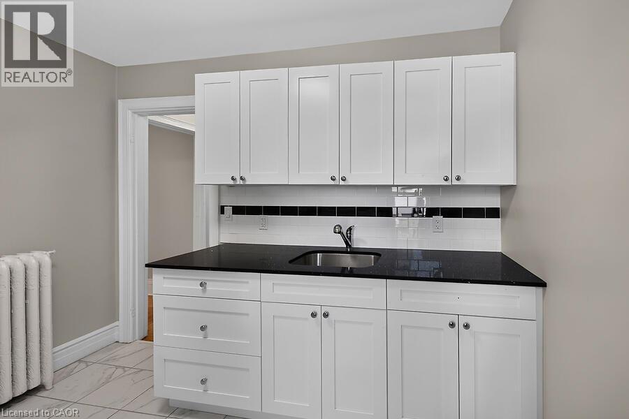 Contemporary white cabinetry with a black countertop and stainless steel sink - 103 Mary Street, Hamilton, ON - Indoor Photo Showing Kitchen