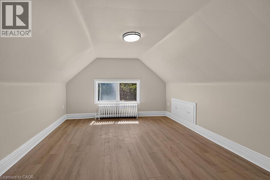 Attic space featuring wood-finish flooring, white baseboards, and a window providing natural light - 103 Mary Street, Hamilton, ON - Indoor Photo Showing Other Room