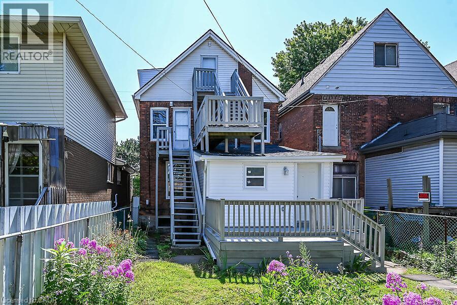 Rear exterior featuring a brick facade with light-colored siding accents - 103 Mary Street, Hamilton, ON - Outdoor