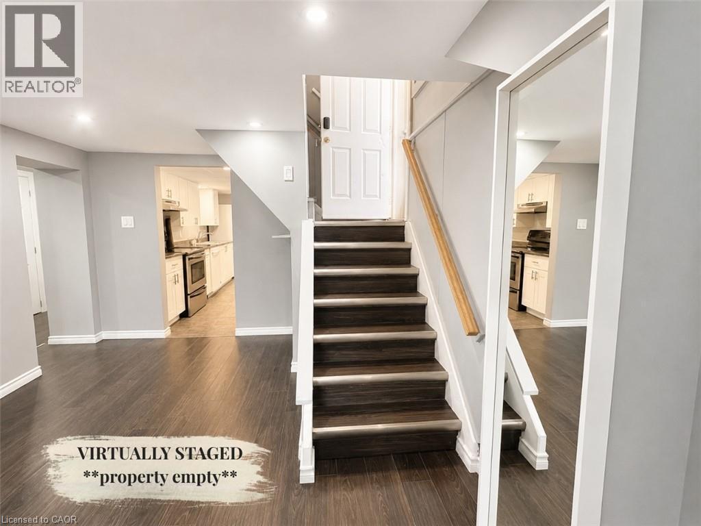 Staircase with wood-finish treads and risers, featuring a light wood handrail - 90 Arlington Boulevard Unit# Bsmt, Kitchener, ON - Indoor Photo Showing Other Room