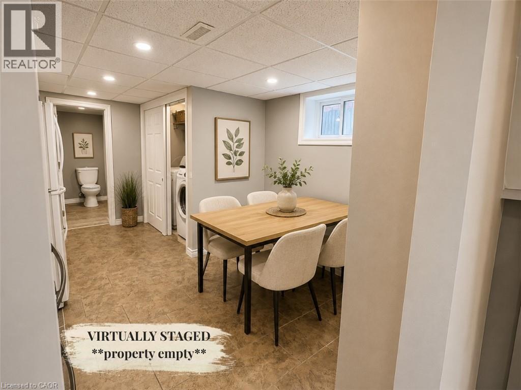 Brightly lit interior space featuring tiled flooring, a discreet laundry area with a stacked washer and dryer, and a partially visible bathroom - 90 Arlington Boulevard Unit# Bsmt, Kitchener, ON - Indoor