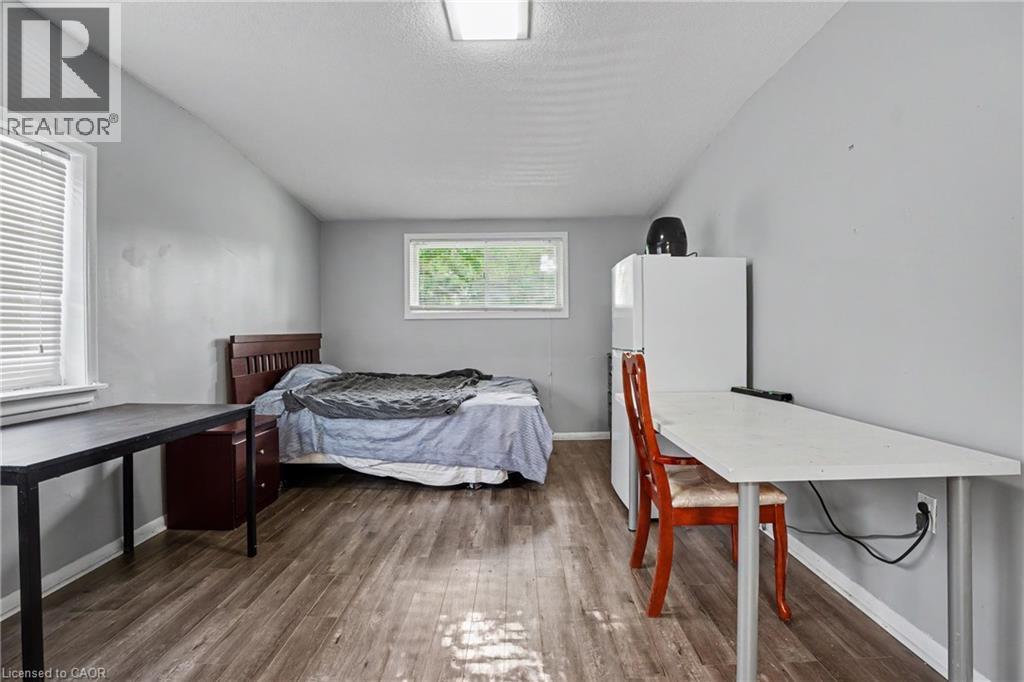 Spacious room featuring wood-finish flooring and light gray walls - 47 Bowman Street, Hamilton, ON - Indoor Photo Showing Bedroom